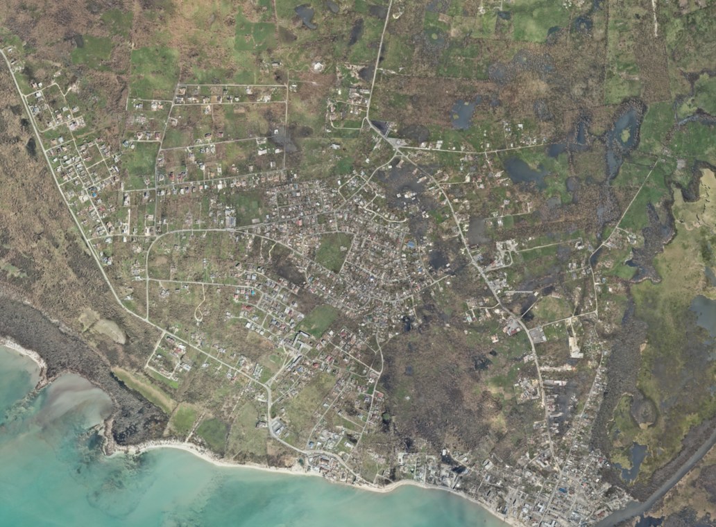 Black River, the St Elizabeth parish capital, seen from a NOAA survey flight on 31 October 2025, three days after Melissa's landfall: browned, stripped vegetation and standing water around homes and the coast road.